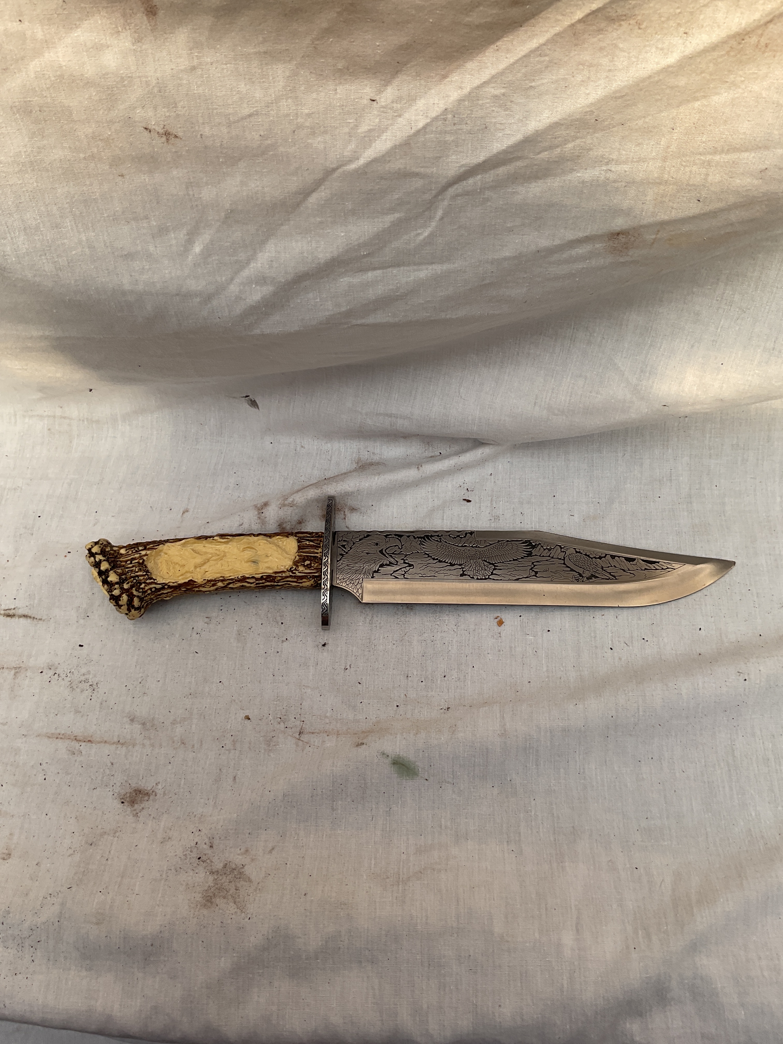 Ornate modern Bowie knife with faux stag grip.