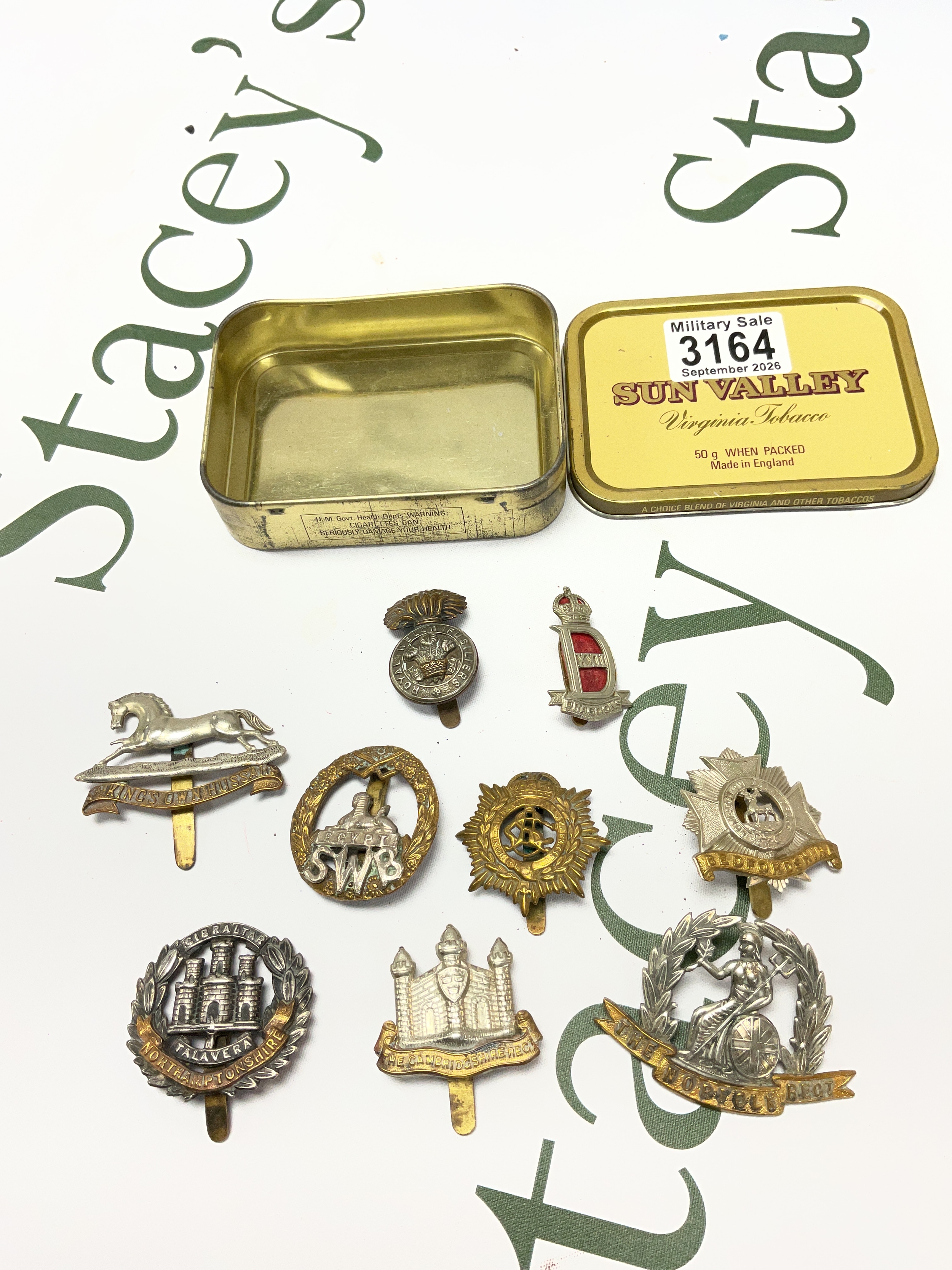 Tin of mixed military cap badges.