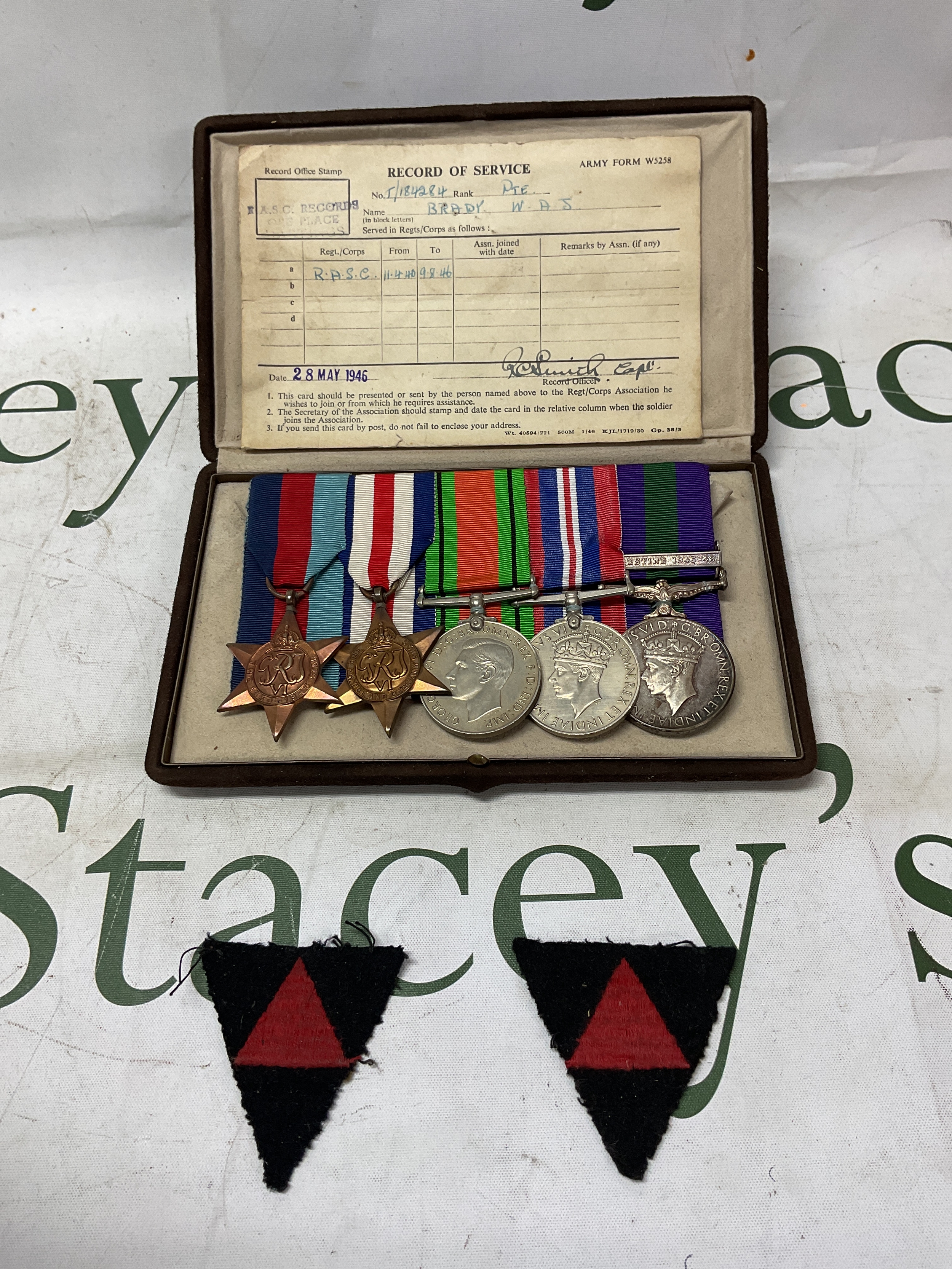 Court Mounted medals to inc, 39-45 star, France and Germany star, DM, BWM,and GSM and bar for Palestine 45-48,  named to 184284 pte W A J Brady RASC. Along with divisional patches and record of service, kept in a Garrards jewellery Box.