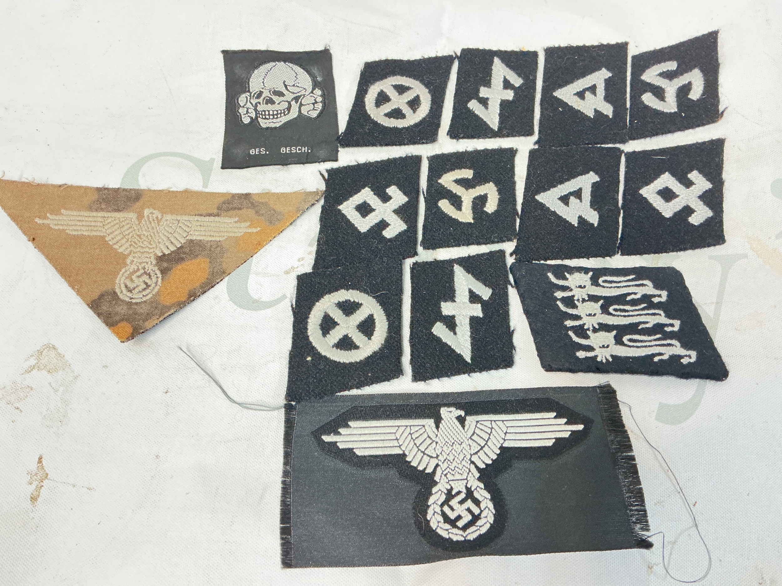 A Collection Of WW2 SS Collar Patches, 2 SS Arm Eagles And SS Cap Skull.