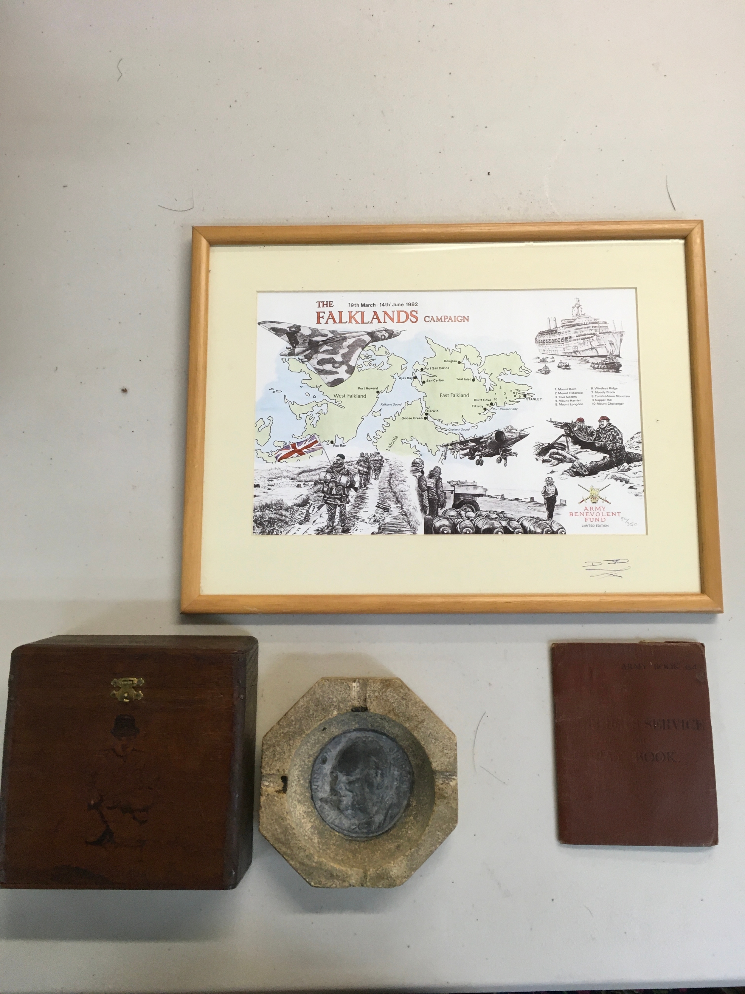 Falklands map, Paybook, and a octagonal stone featuring a Churchill medal in the middle 