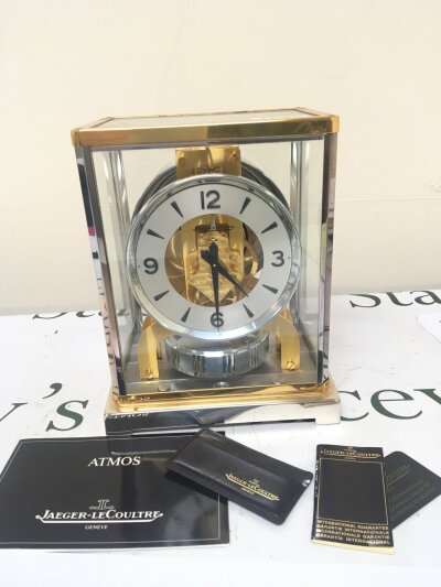 A Jaeger-Le-Coultre Atmos clock finished in chrome and lacquered brass the clock sold with original International Guarantee card and paperwork.