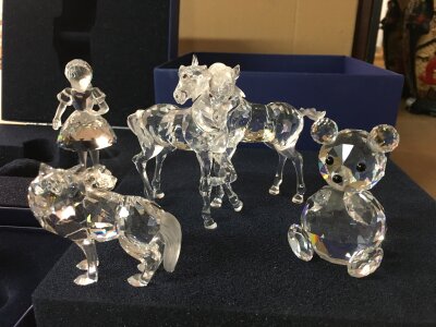 Four Swarovski figures including fox, horses and doll