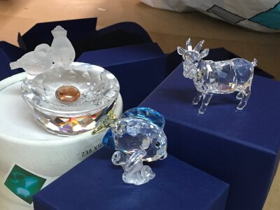 Three boxed Swarovski pieces including goat, fish and pair of birds at a water bath