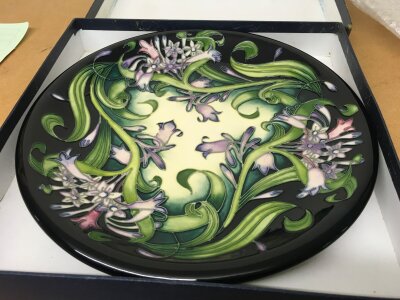 A Moorcroft plate decorated in the Isis pattern with original box .