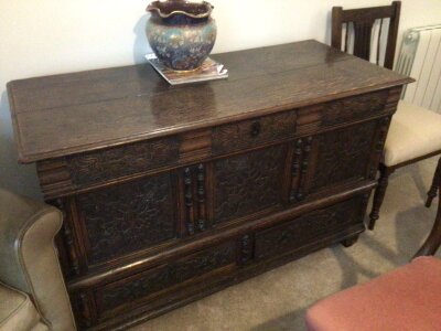 An 18th century oak vernacular Mule chest with a hinged top above carved oak panels and applied mouldings above drawers length 125cm