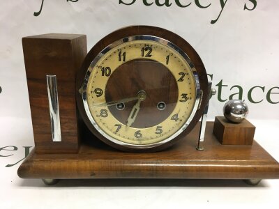 An chrome and oak art deco design mantle clock with an 8 day wind wind up movement.
