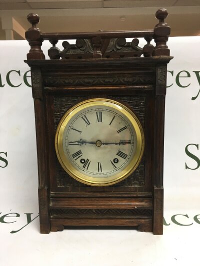 A late Victorian bracket form mantle clock with a carved front.