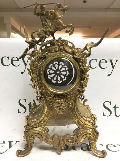 An antique rococo style french brass coloured mantle clock case.