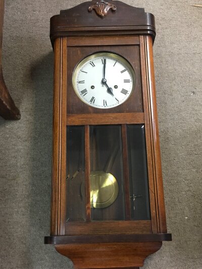 An oak wall clock with pendulum and key, 80cm tall