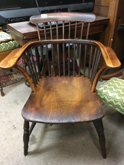 A Elm stick back open armchair the solid seat on turned legs United by stretchers .