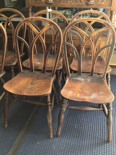 A set of six 19th century British Vernacular Elm and Beechwood chairs with arched backs above solid seats on turned legs (6)