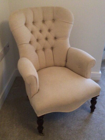 A Victorian style modern arm chair with button back upholstery.