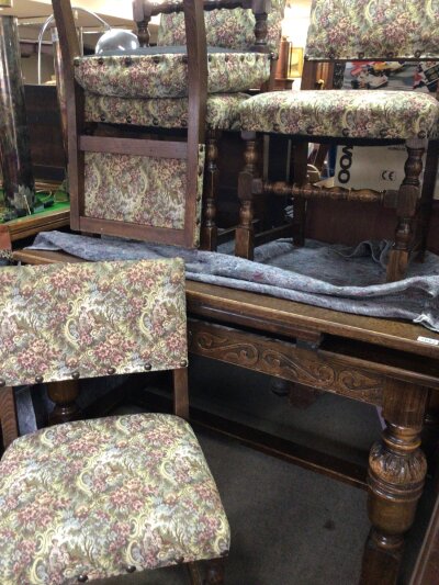 An oak drawer leaf dining table with bulbous legs and set of four conforming chairs.