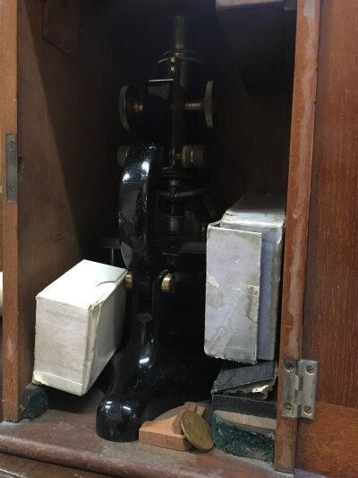 A student’s microscope with slides, fitted in a mahogany case