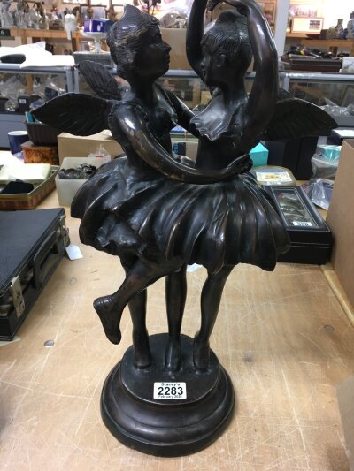A bronze figure in the form of two dancing fairies.