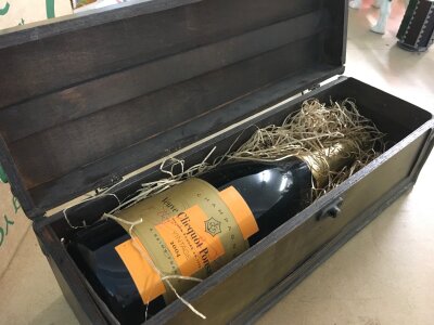 A vintage bottle of Clicquot 2004 champagne in a wooden case