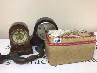 A basket containing Antique lace an oak mantle clock one other clock. And a vintage woodworking tool a brass mounted brace.