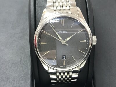 Oris Artelier Date watch features a stainless steel case and bracelet with a grey guilloché dial. Approximately 40mm case. Box and papers. Seen running.