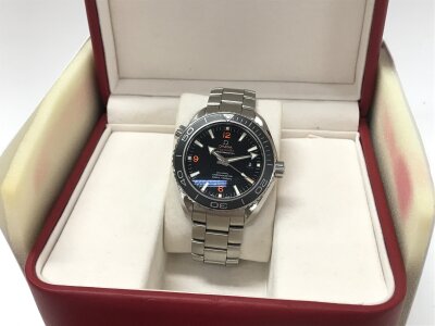Omega Seamaster Planet Ocean 600M features a black dial with distinct orange Arabic numerals at the 6, 9, and 12 o'clock positions. Seen working. Comes with box and cards.
