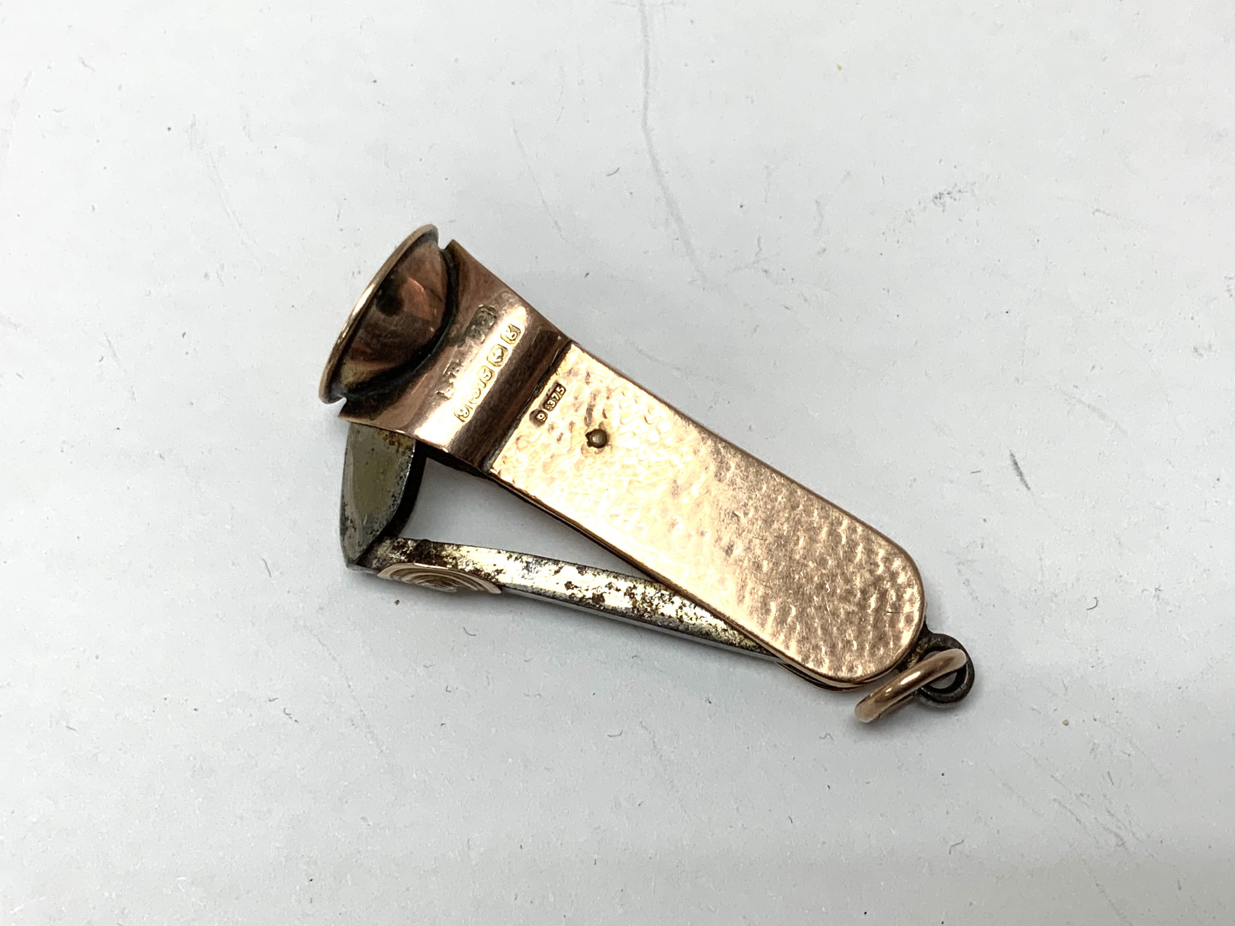 A 9ct gold cigar cutter. (A)