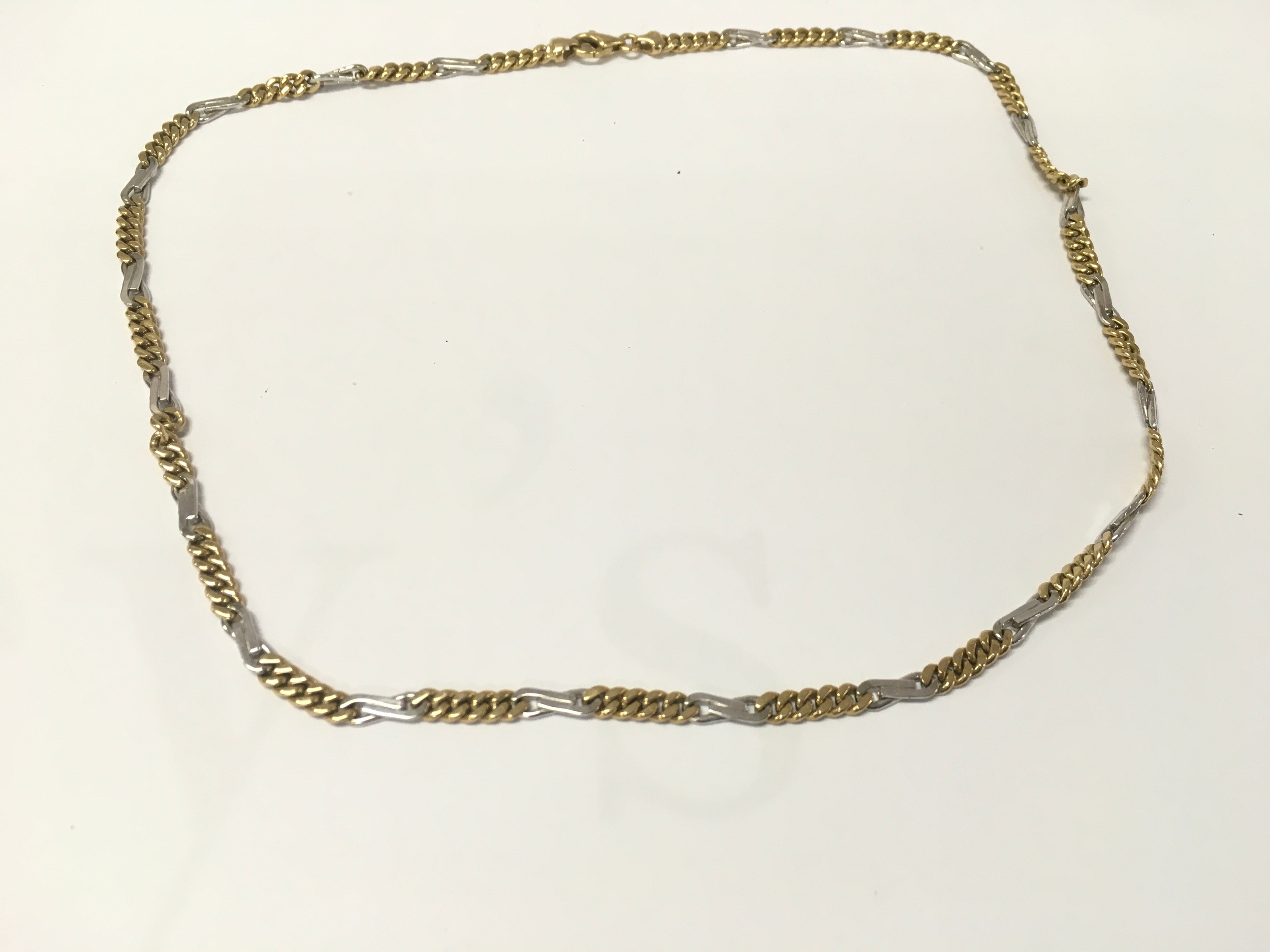 A 9ct gold bi-colored design alternating yellow and white gold curb link sections 
23.7g