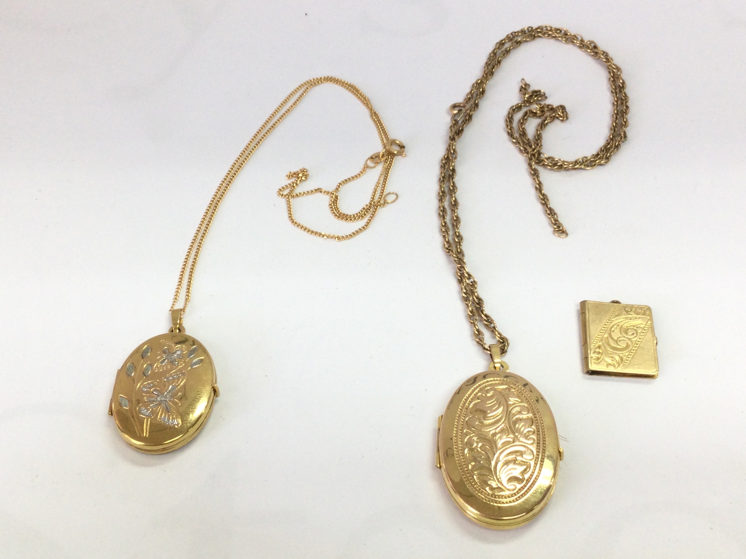 Three gold pendants and chains . 1.9g total weight 