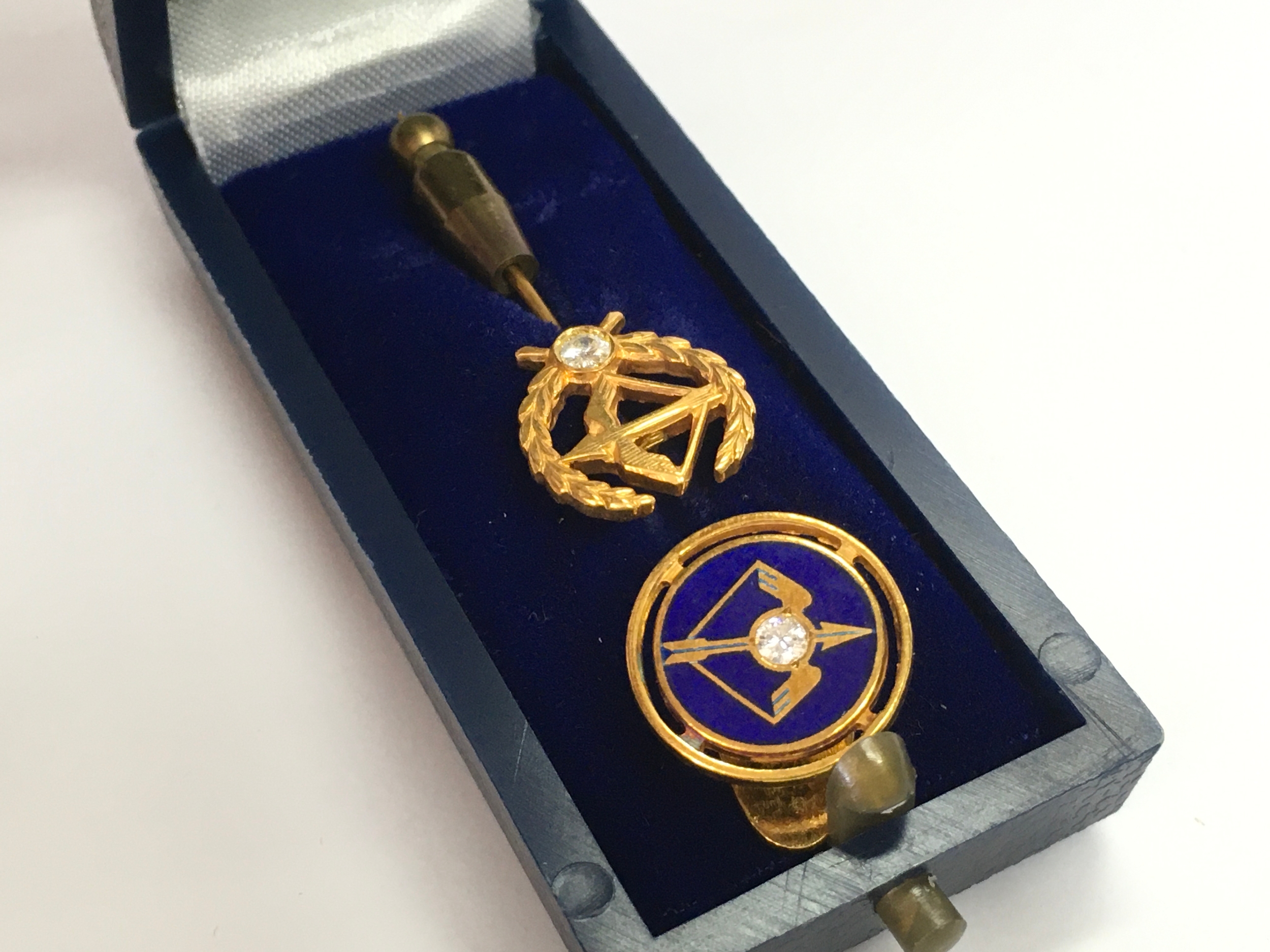 A tie pin (marked 18ct gold) and tie stud , crossbow design . 