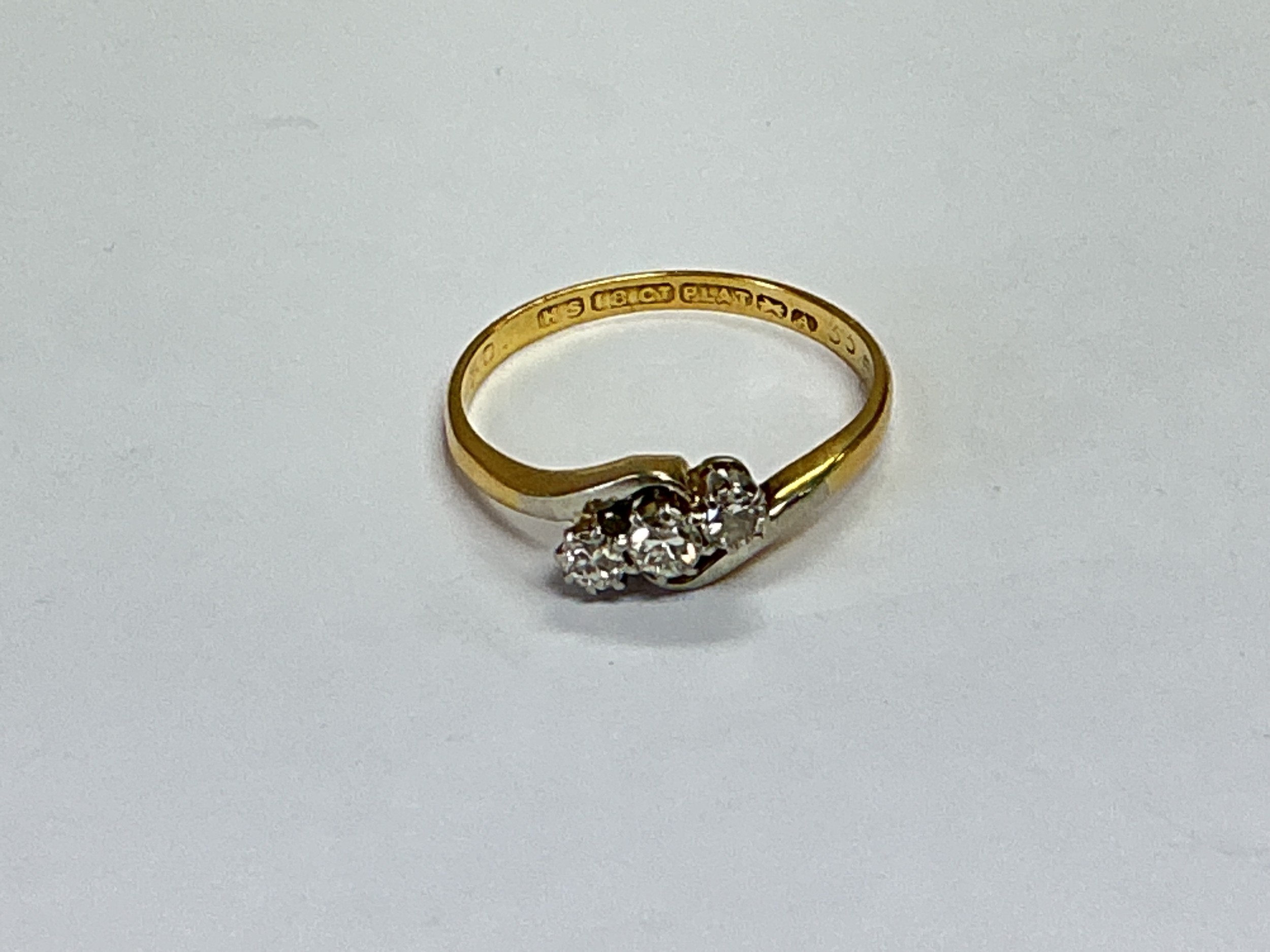 An 18ct gold and platinum ring set with three diamonds, approx 2.3g and approx size M-N.