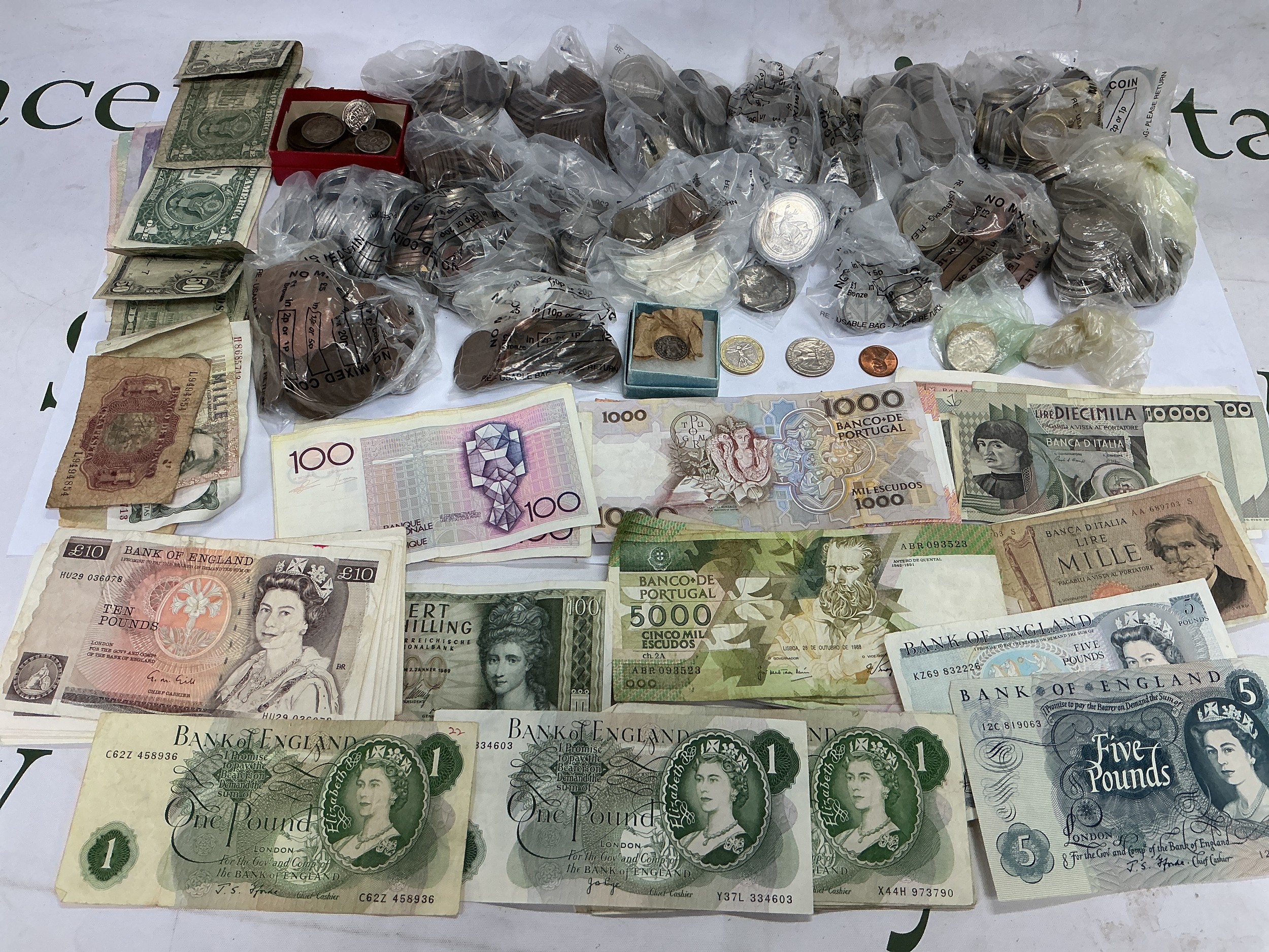 A collection of GB and world bank notes and coins.