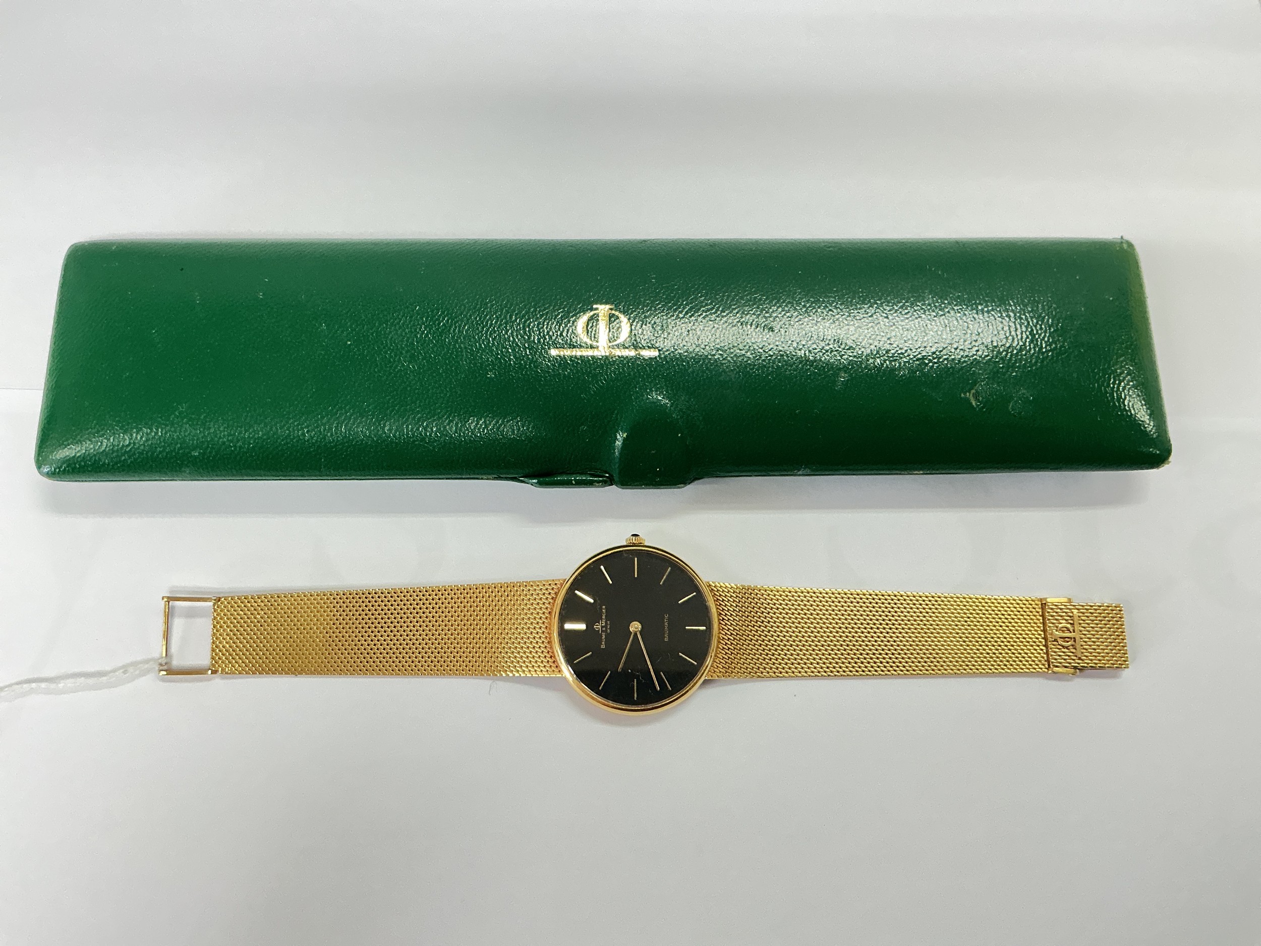 An 18ct gold Baume & Mercier watch with black dial and baton numerals. Comes with original case.