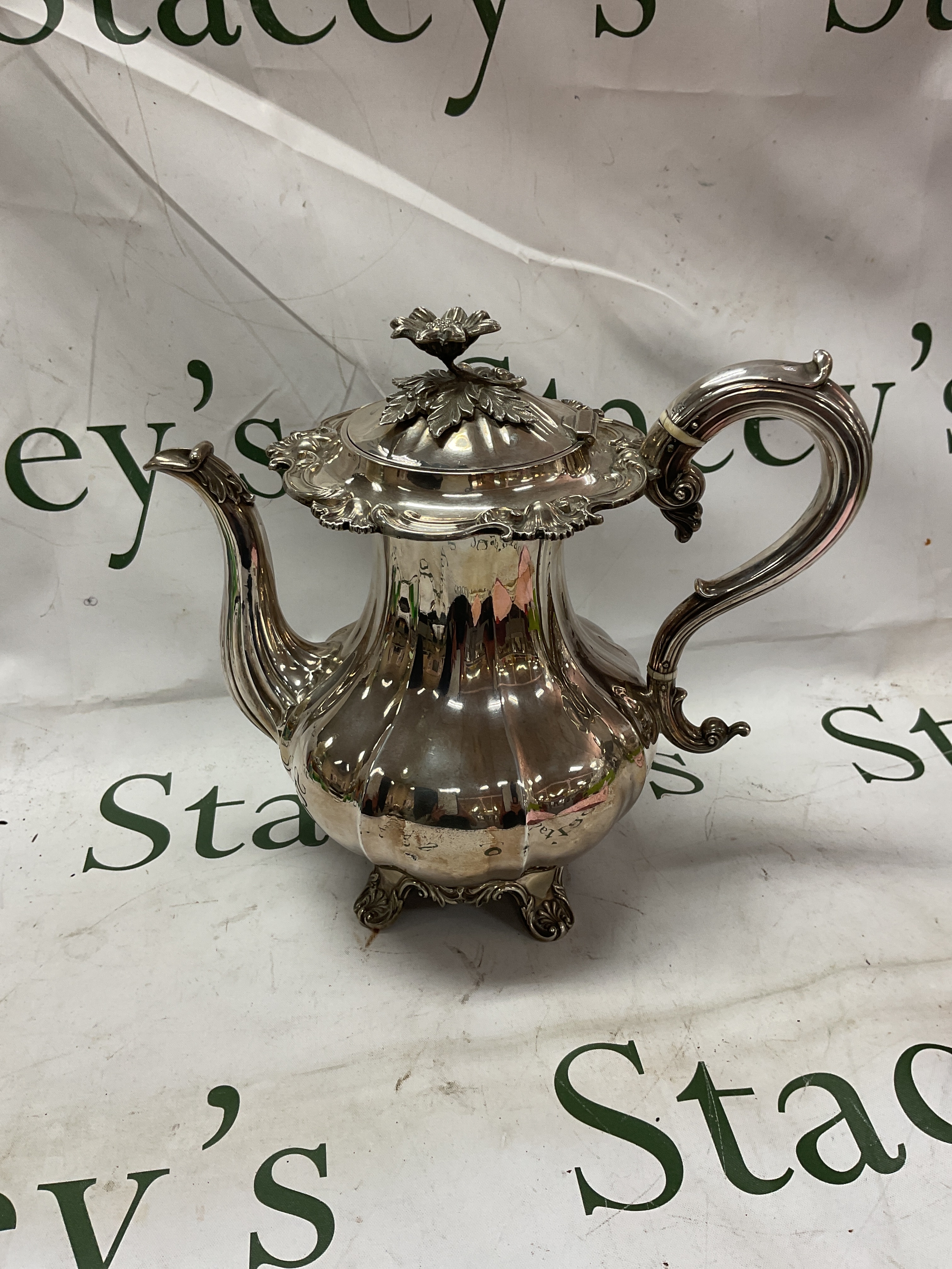 Victorian HM Silver tea pot Sheffield 1846 by Hawksworth Eyre and Co, weight 900 grams. Gadrooned body with stylised flower finial to the lid, with heat dissipaters to the handles,on heavy floral scroll feet.25 cm high.