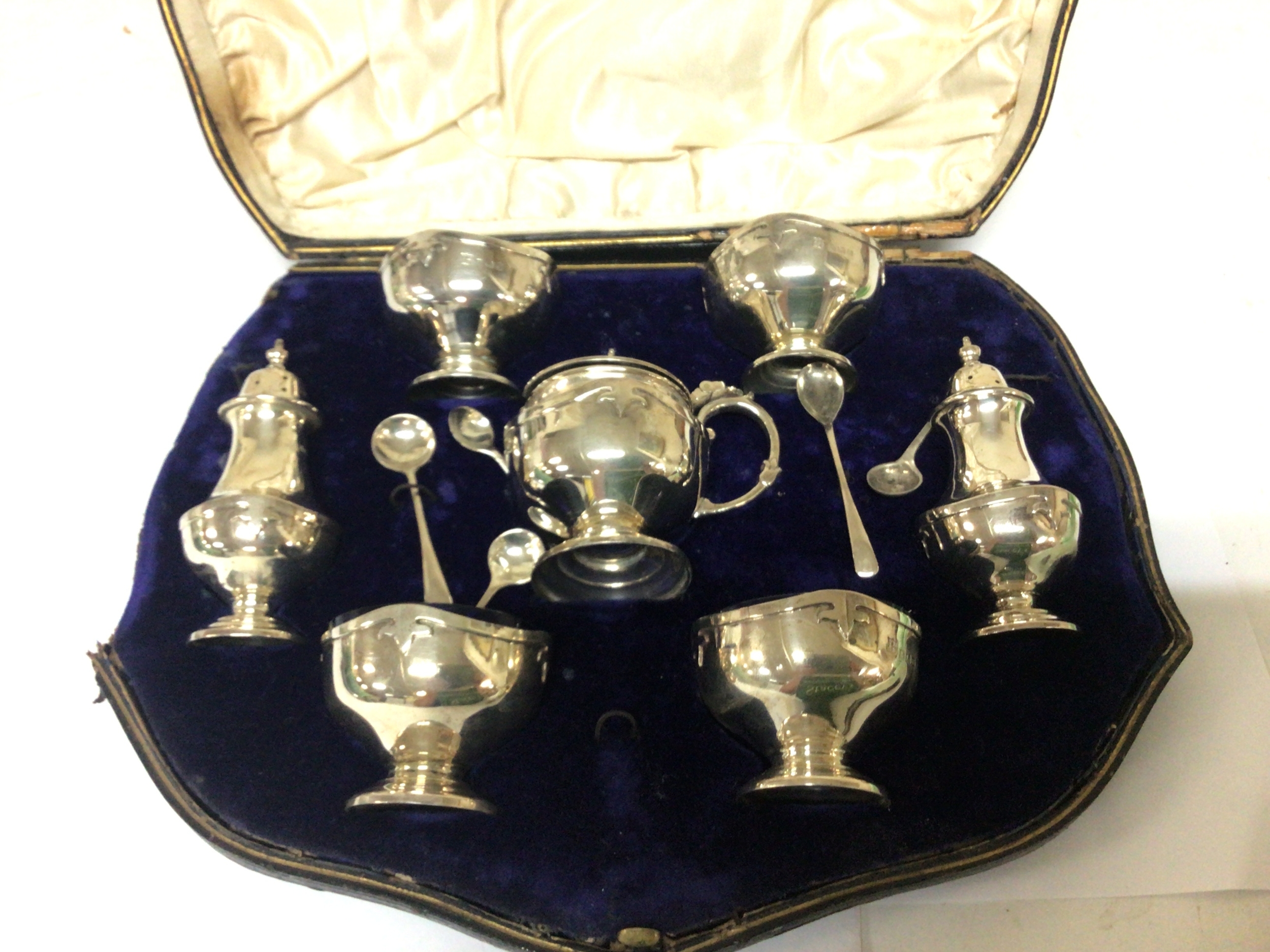  A nice quality silver condiment set in a fitted box with Birmingham hallmarks the salt pots with blue glass liners 
