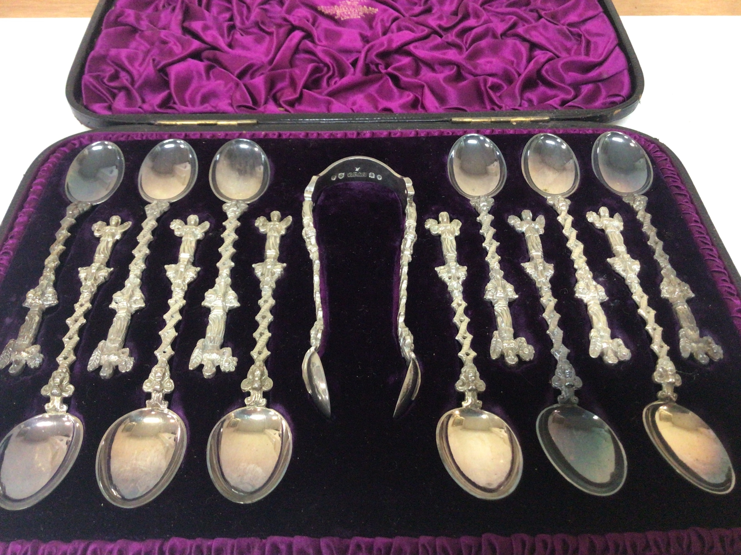  A well presented Victorian Scottish set of silver spoons and sugar tongs in a fitted case with solid cast stems with Renaissance inspired figures. Scottish hallmarks Edinburgh. 