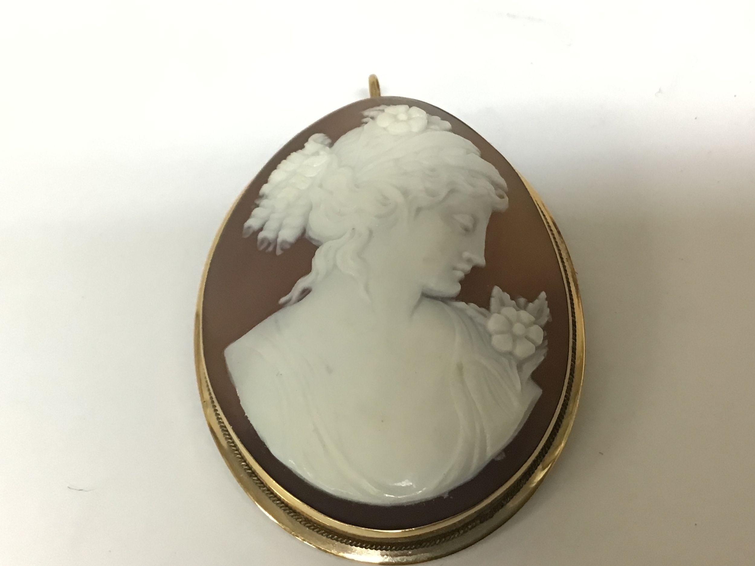 A quality Cameo brooch set in an oval gold mount possibly 18carat indistinctly marked the Cameo with a classical side portrait of a young lady signed to the reverse 48mm x 36mm. 