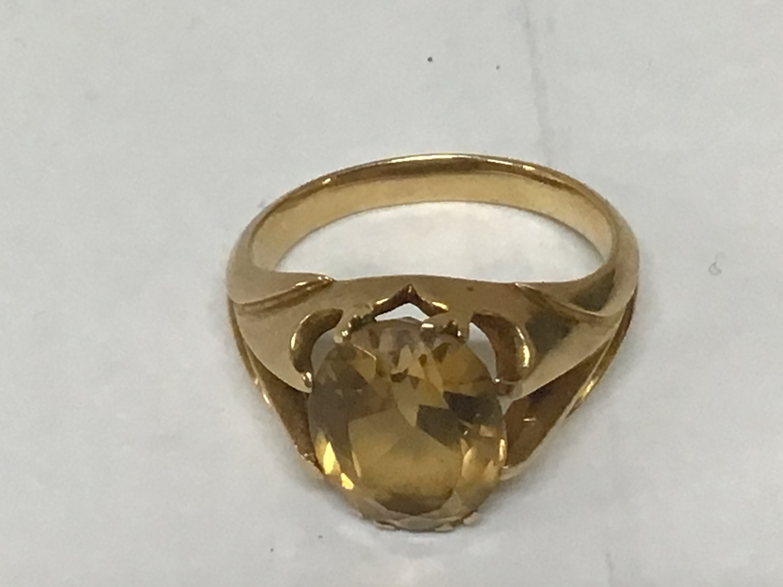 An unmarked gold ring set with a a cut oval citrine stone weight 7g 