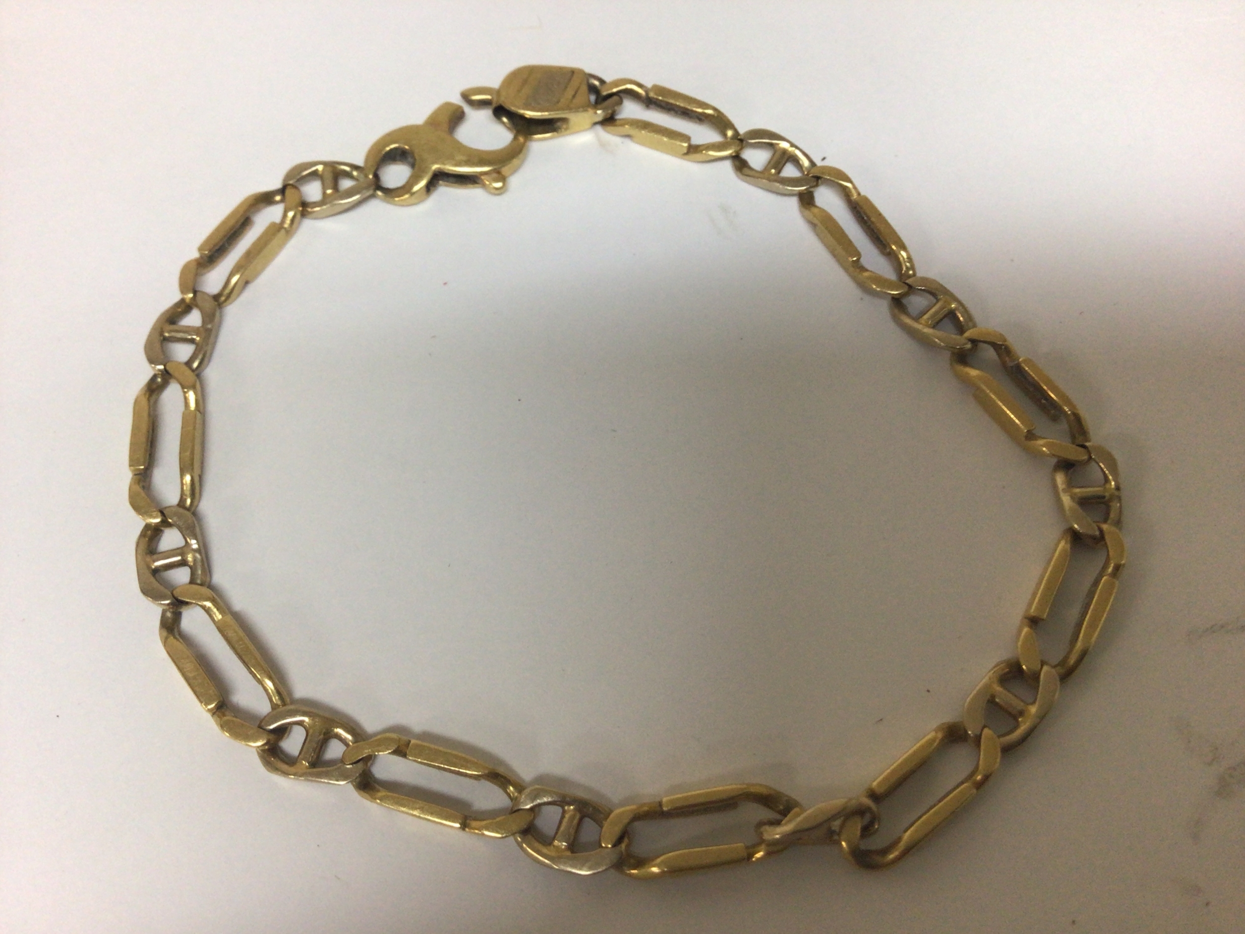  A  yellow metal bracelet with open shaped links obscured marks most likely 9cart. Weight 15g approximately. 