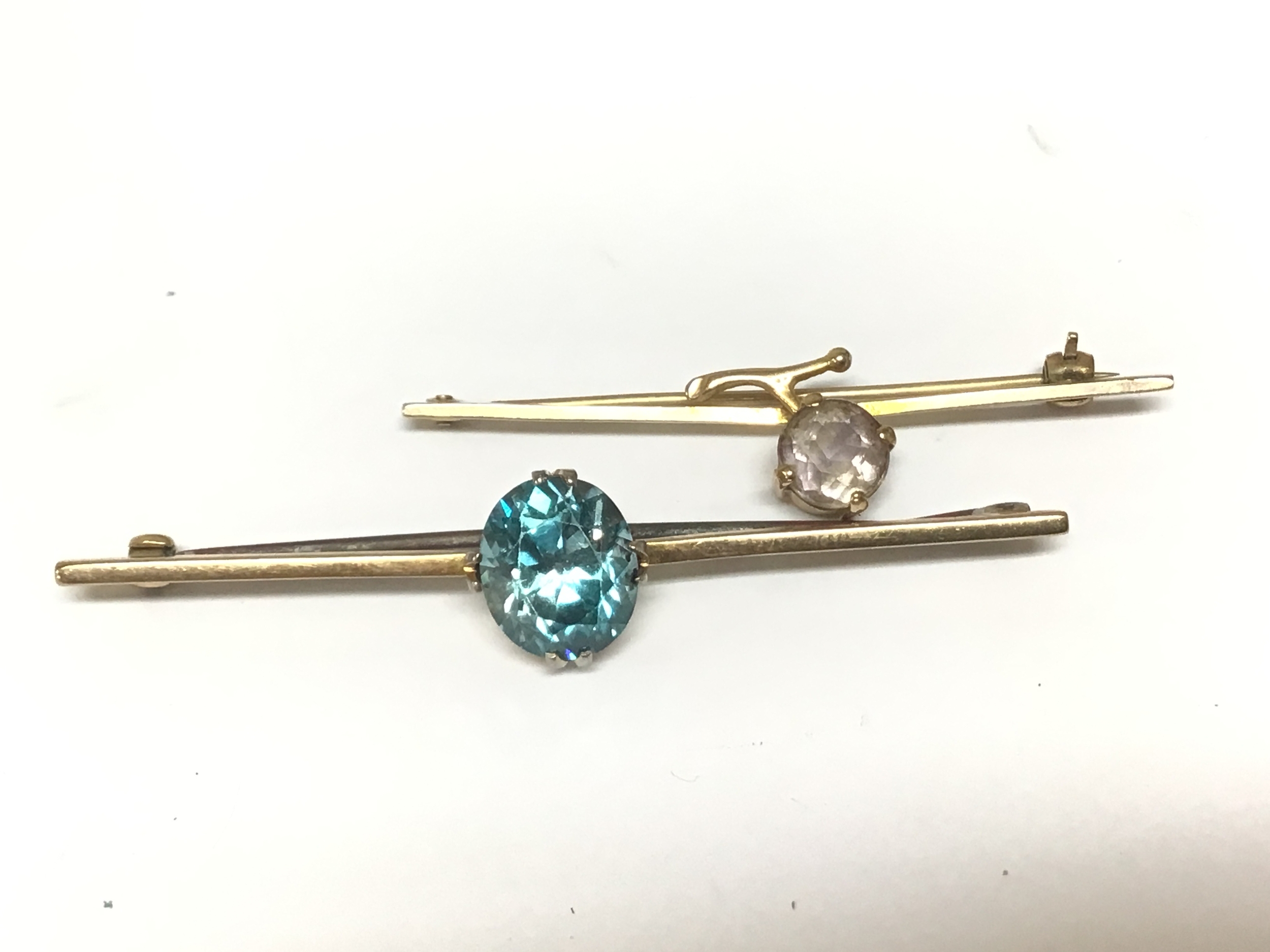 Two gold bar brooches set with a vivid blue Zircon and one other gold brooch set with a quartz stone. Total weight 8.5g 