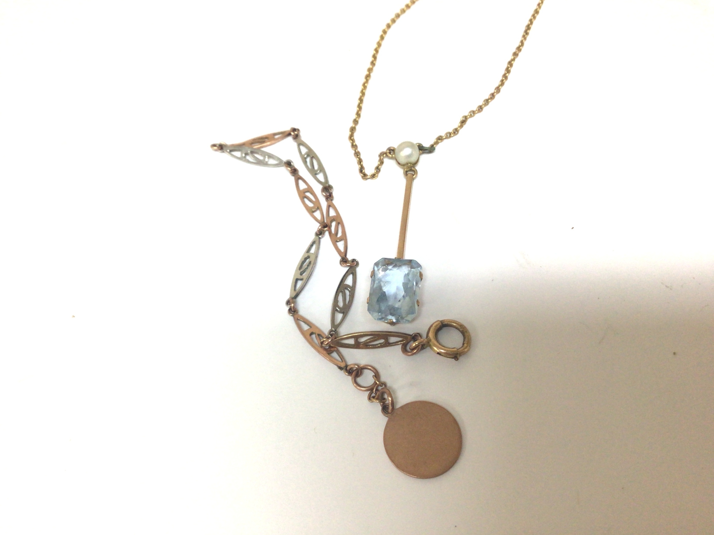 A 9carat gold bracelet with alternating white and yellow open gold links weight 2.5g and a necklace with aquamarine coloured pendent with seed pearl.
