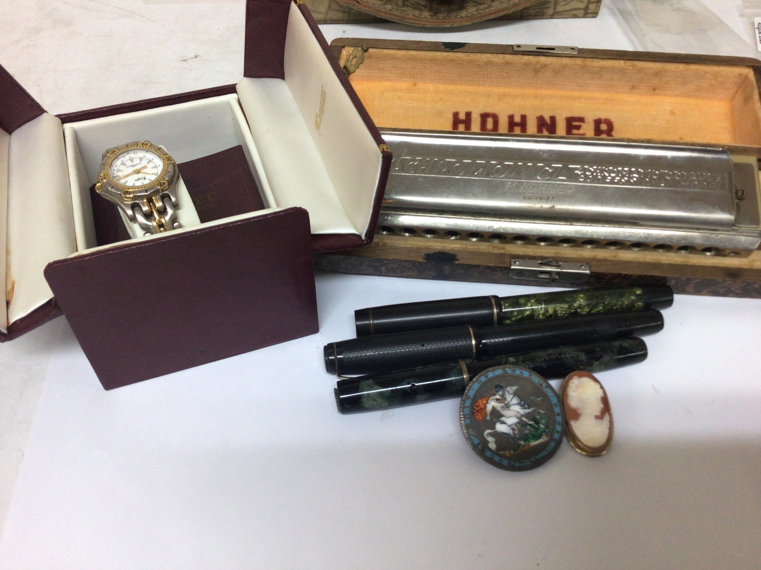  A silver and later enamel decorated coin brooch a cameo brooch fountain pens a Hohner mouth organ and ladies Luger Swiss watch (a lot) 