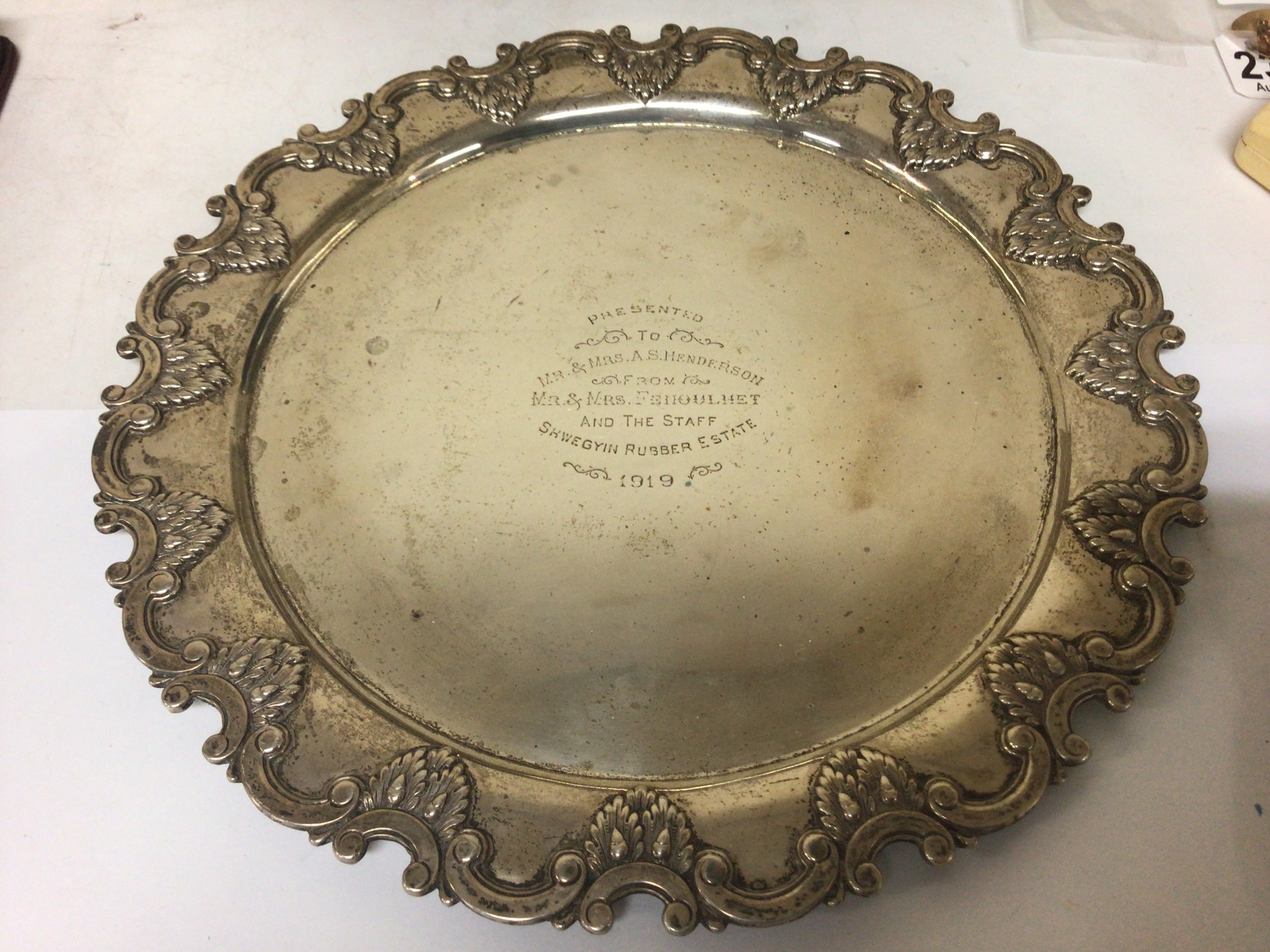  A Silver tray with inscription Shwegyin Rubber Estate 1919. With a raised patterned edge with C scrolls and acorn leaves. The reverse marked Silver 18. Weight 495g 