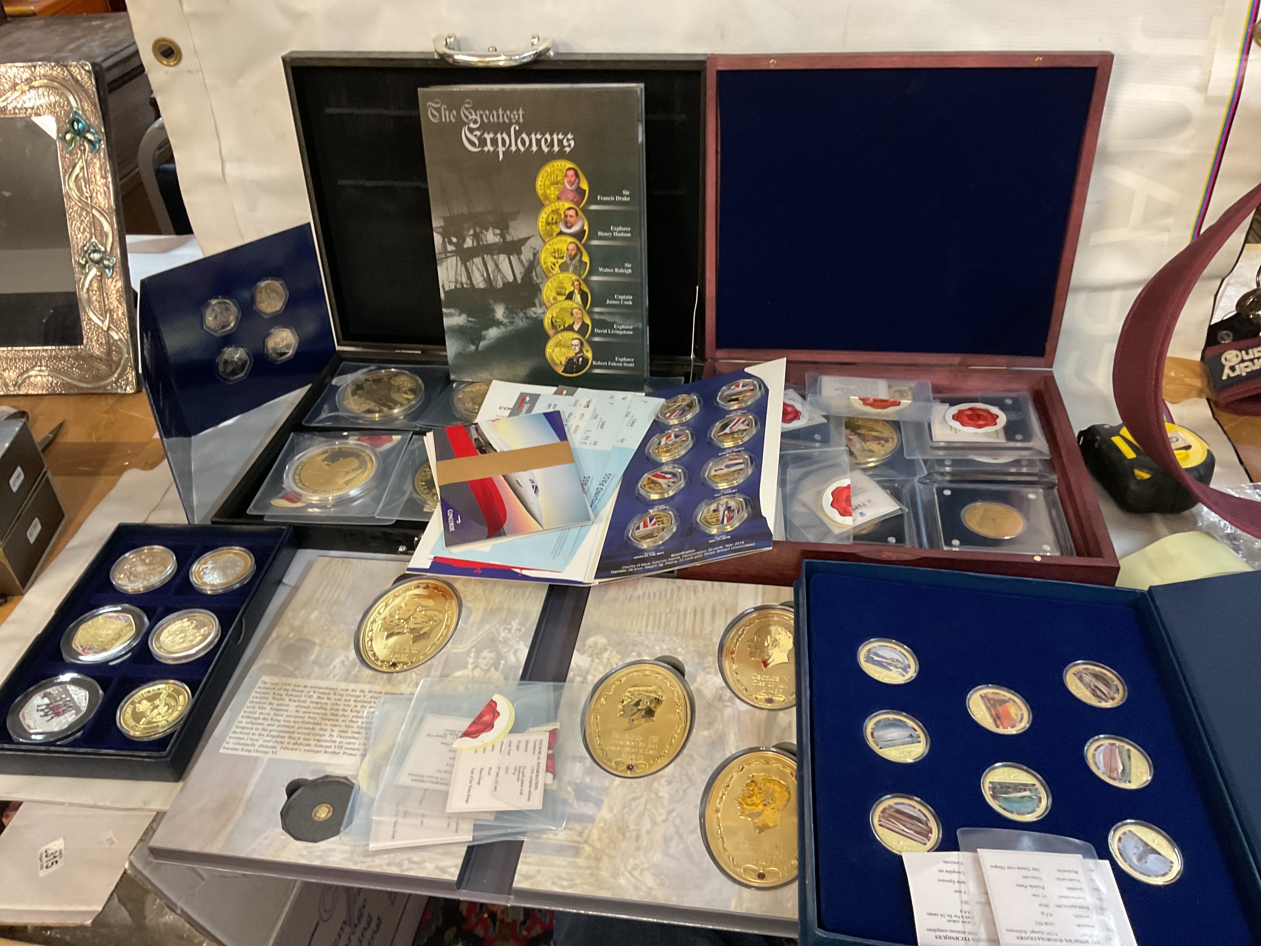 A collection of cased commemorative coins including Concorde and change checker items.