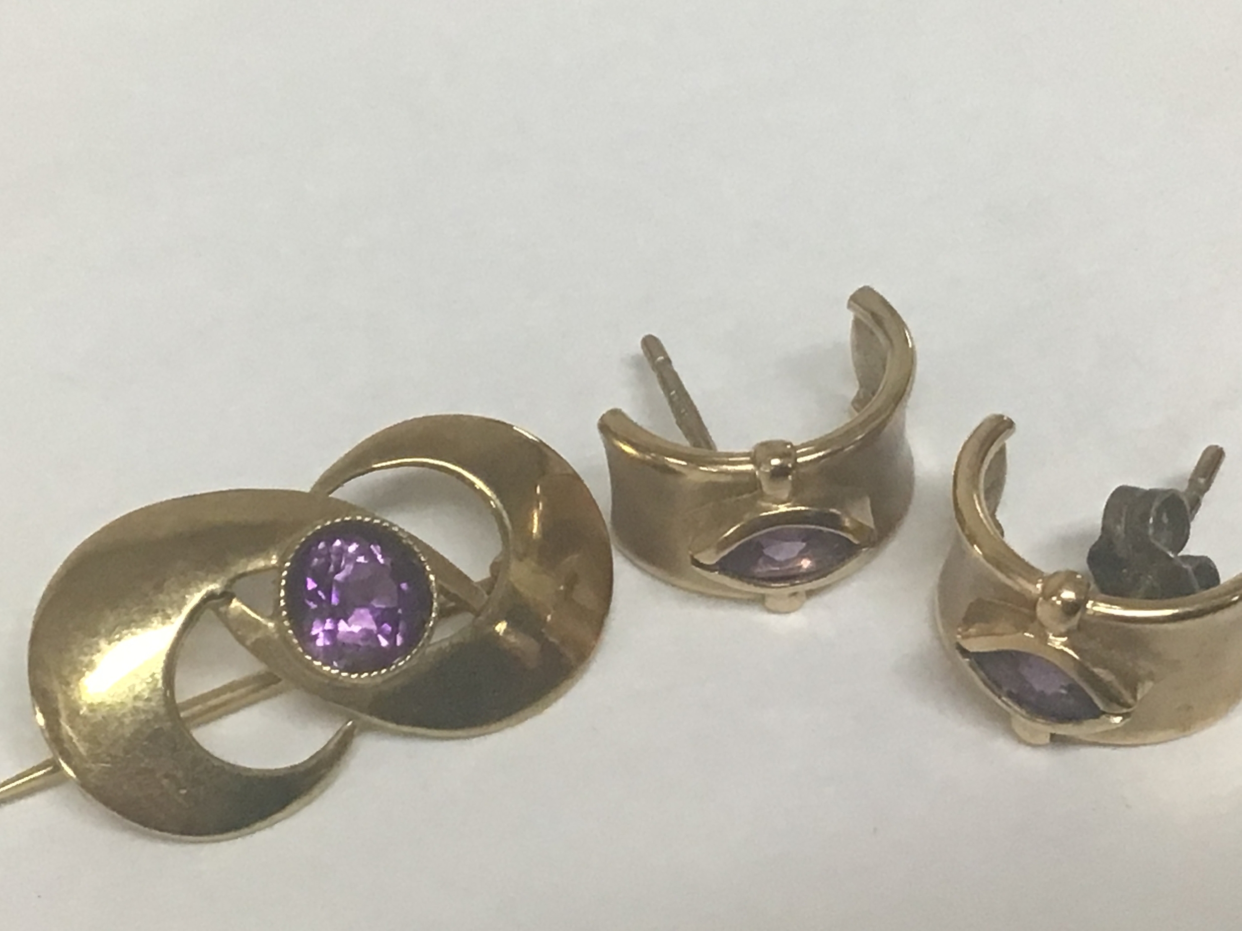 A pair of 9ct gold earrings set with amethyst and a similar 9ct gold brooch. Weight 5.5g