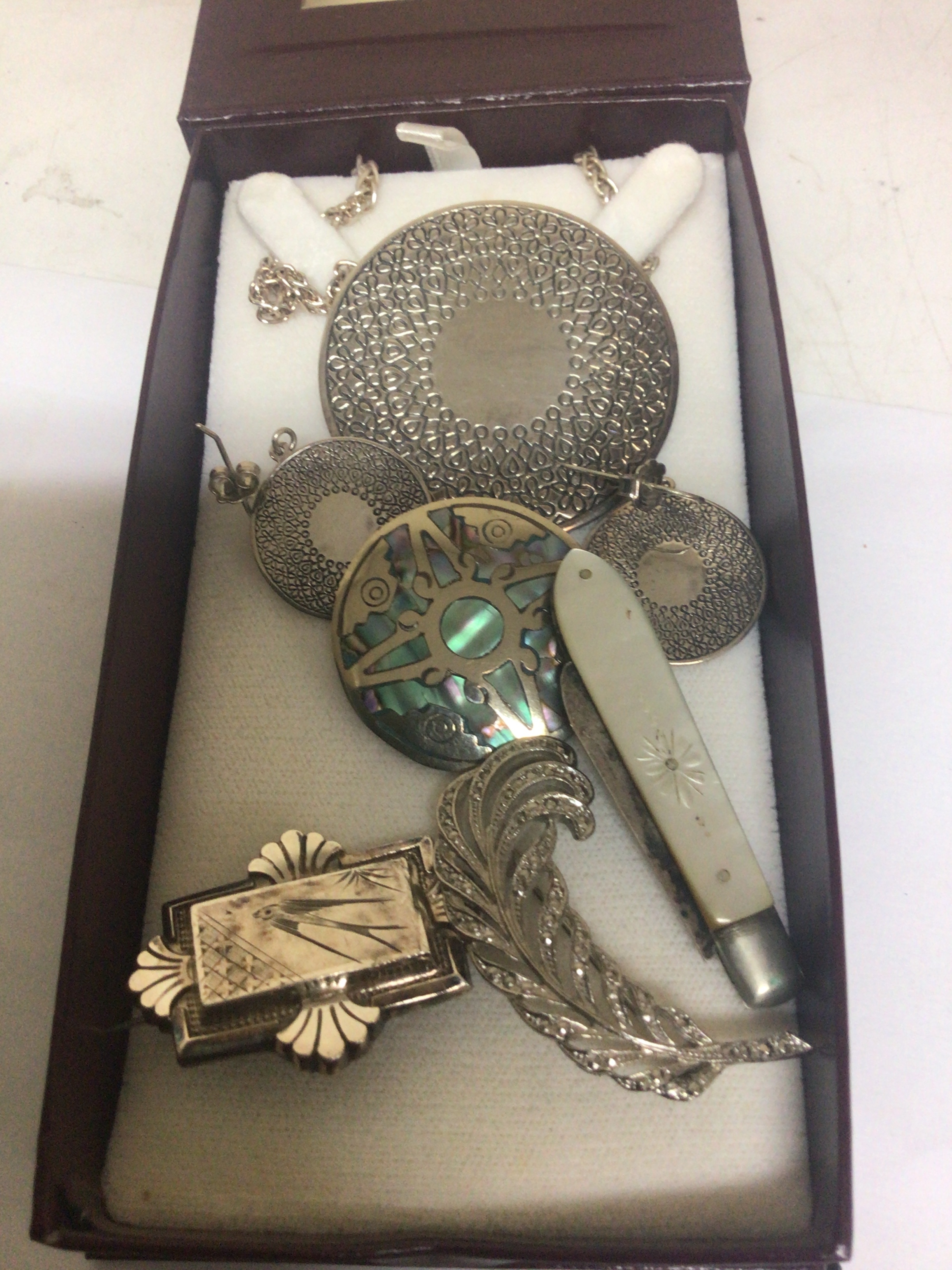 A modern silver circular shape with earrings silver brooches a silver folding Knife and an Elizabeth R pendent in fitted box.