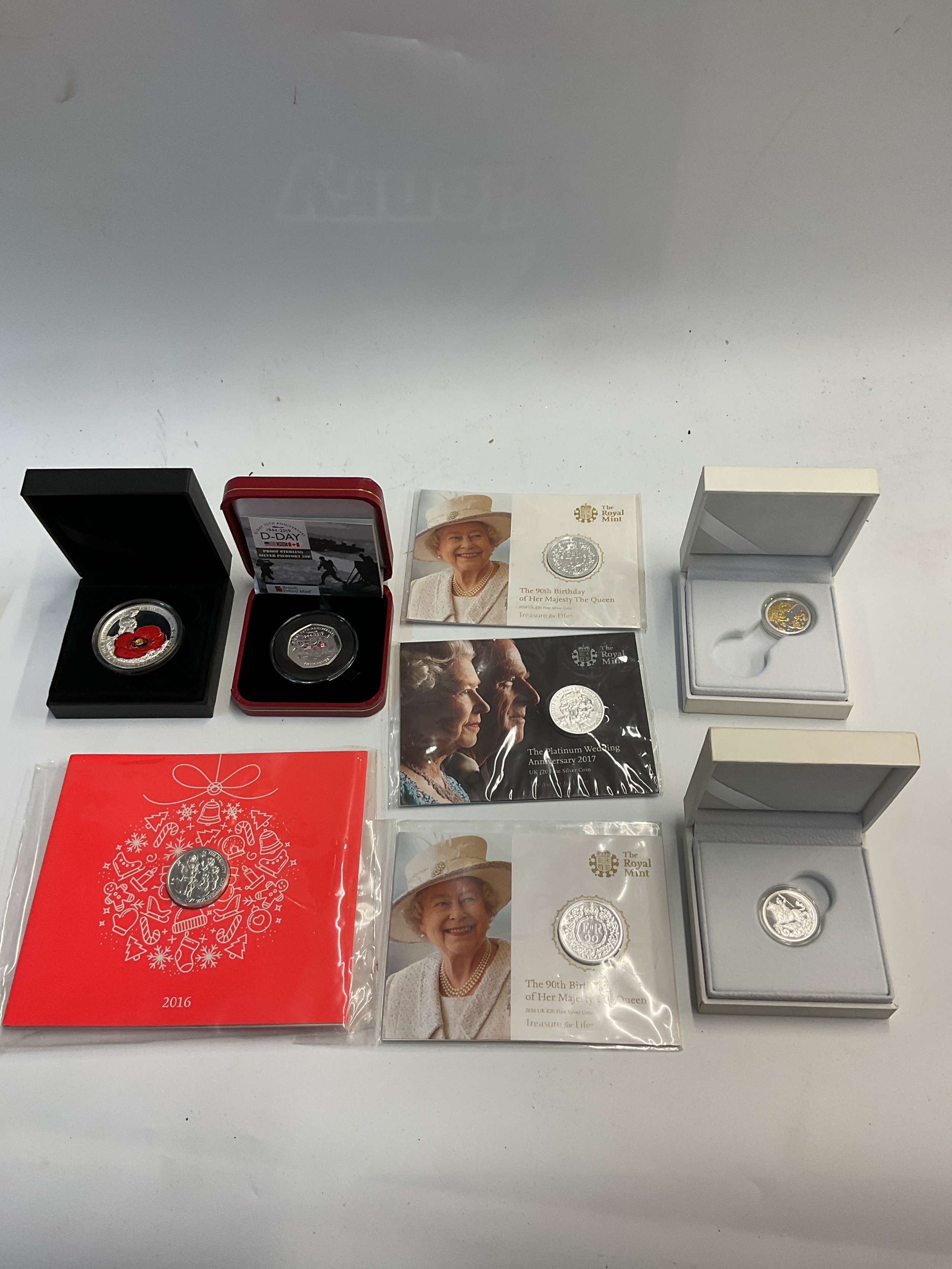 Two cased silver Sovereigns, four silver £20 coins, a D-Day piedfort proof 50p and a cased silver poppy crown.