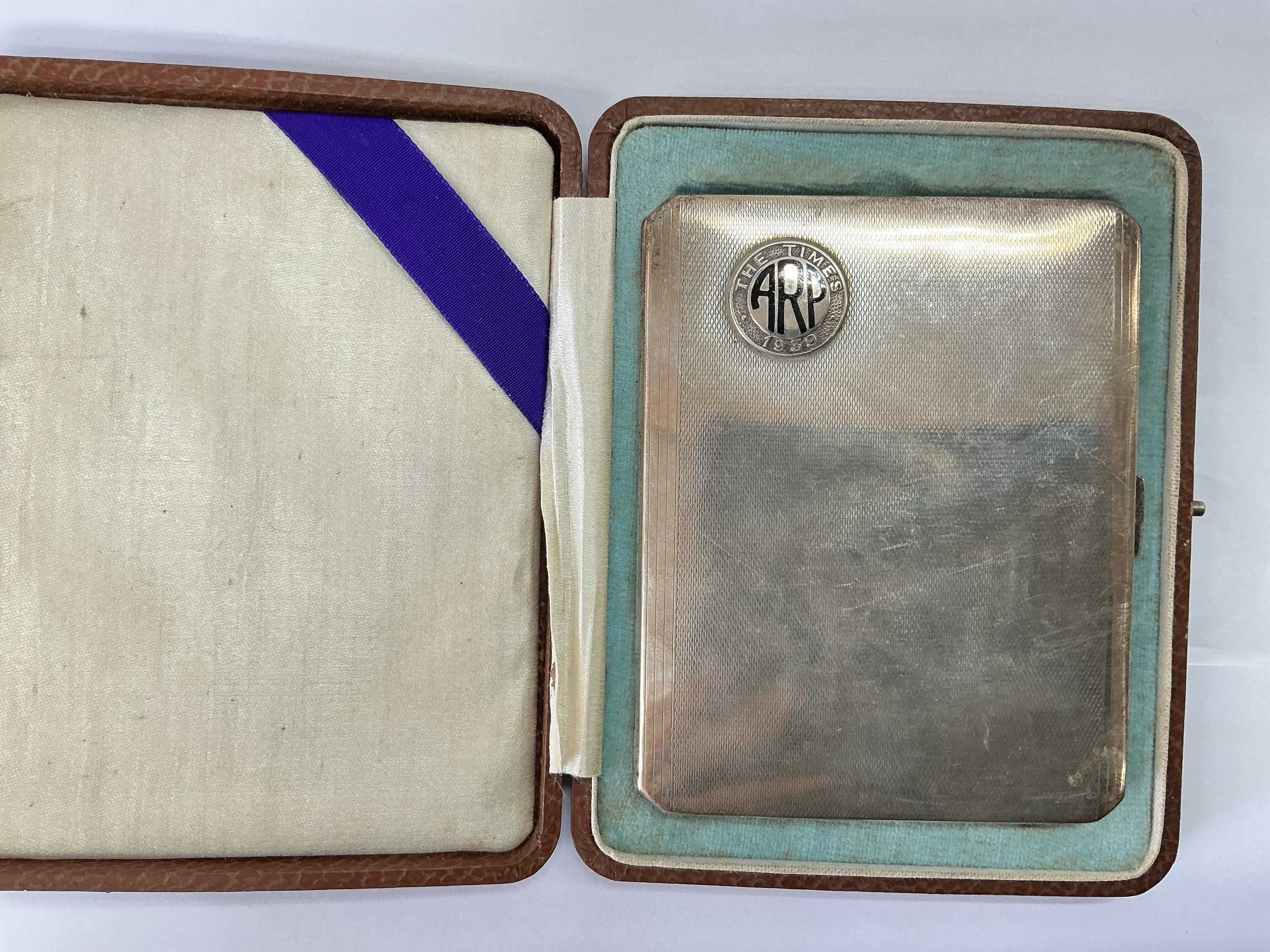 A silver cigarette case with ARP embellishment, London hallmarks.