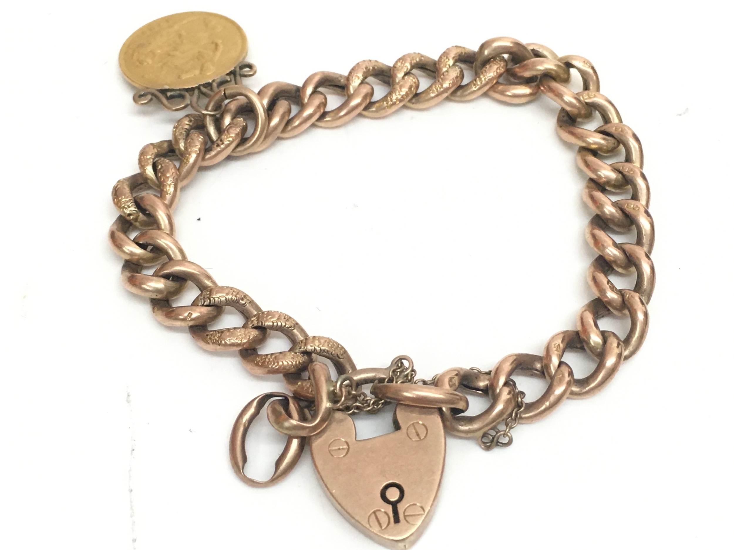 A 9ct rose gold curb link bracelet features a heart-shaped padlock clasp and 1903 half sovereign. 21.9g total weight. 9cm wide