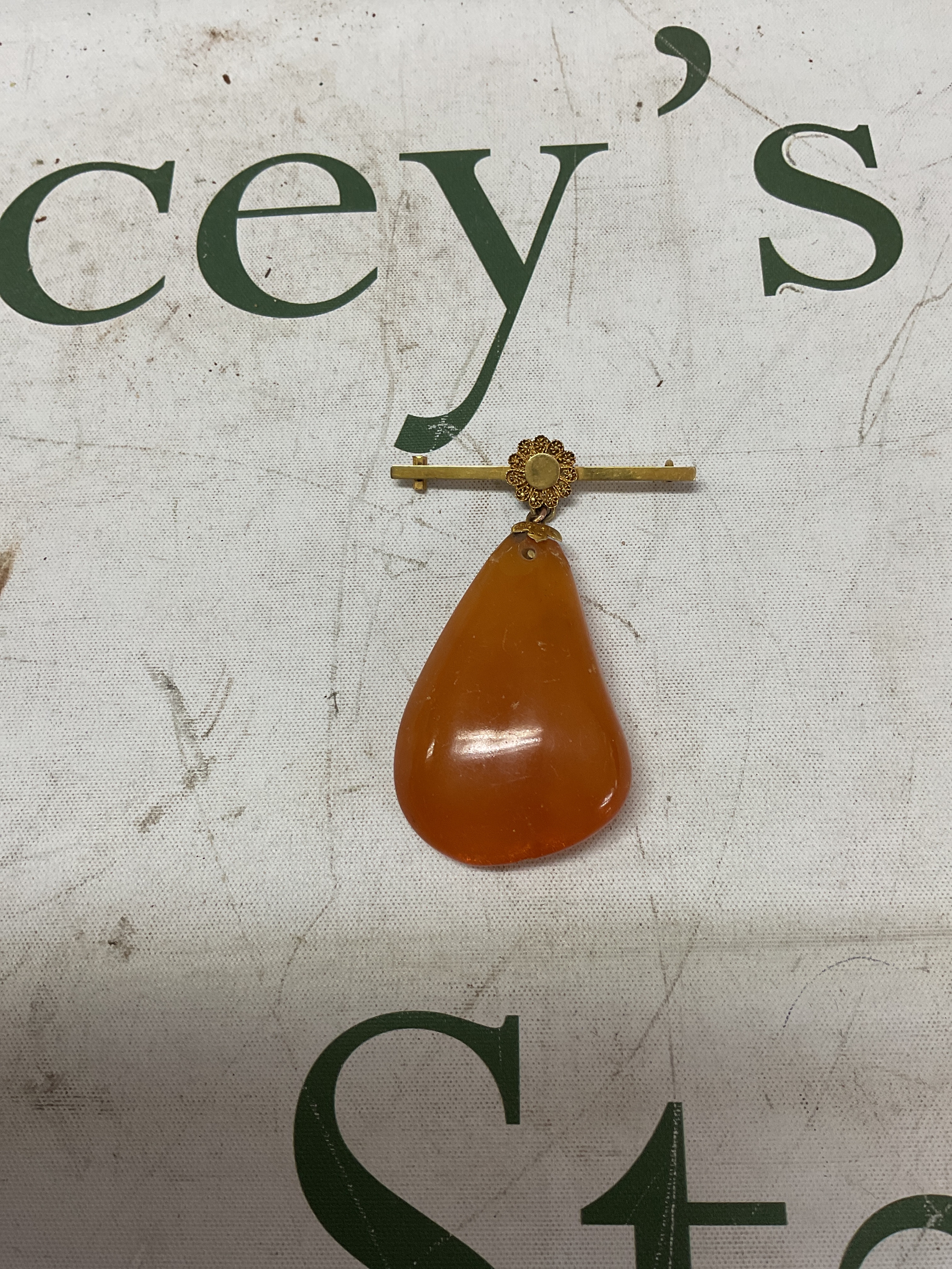 Large amber pendant on yellow metal mount.