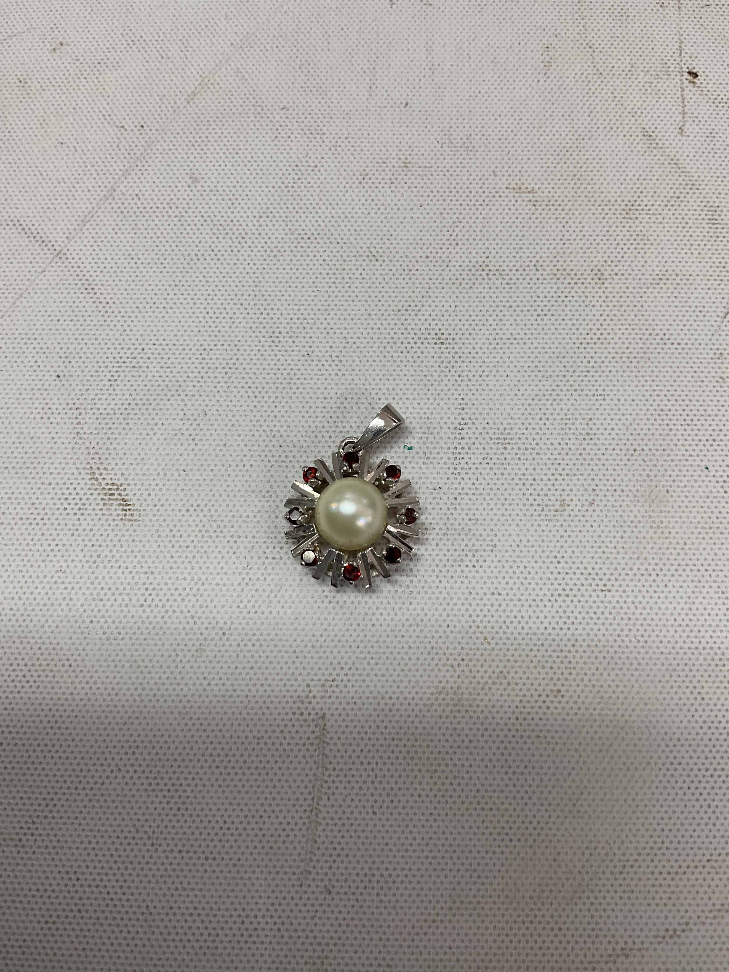 18 k white gold pendant set with re stones and a pearl. Weight 2.7grams.