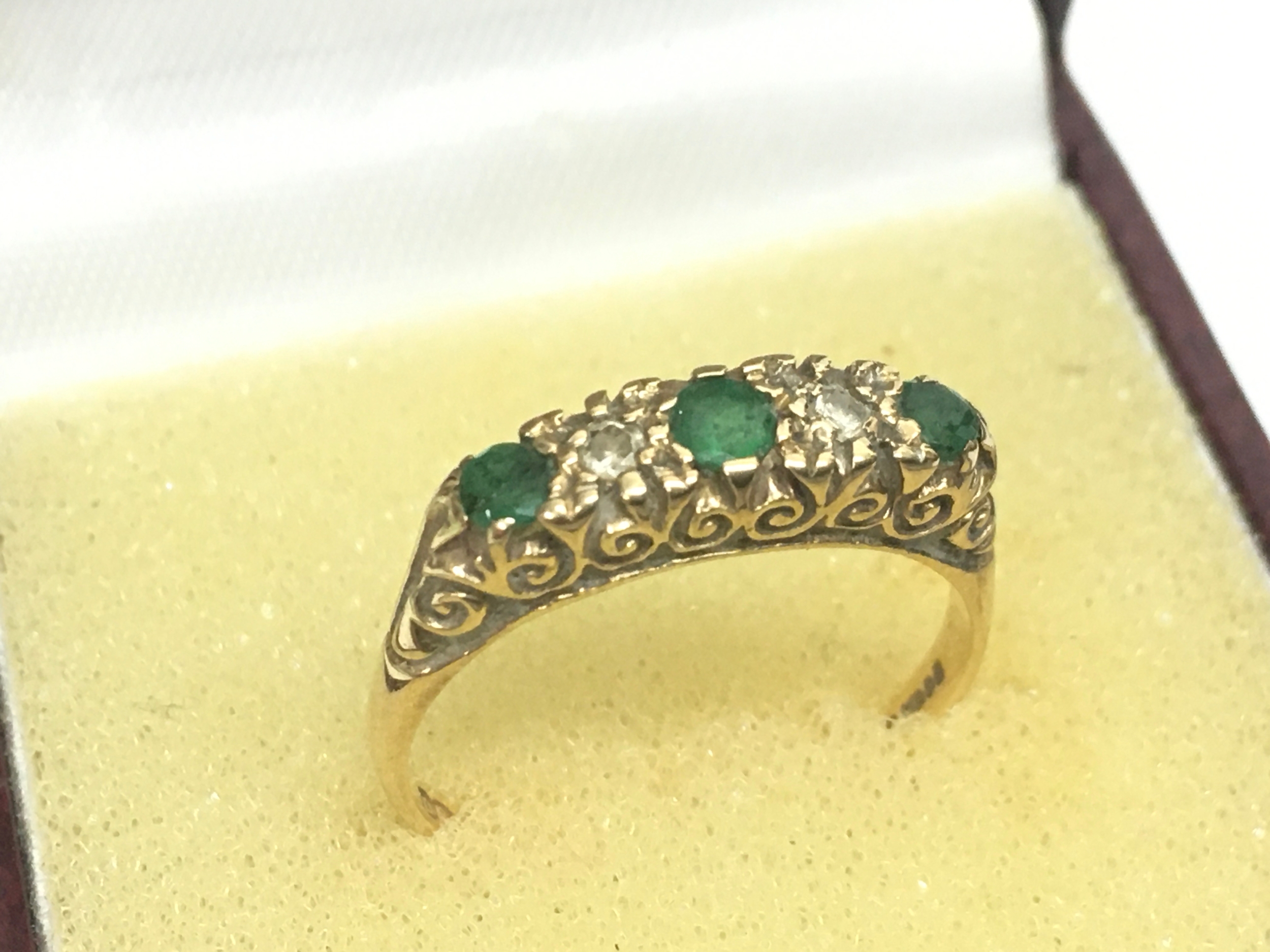 A 9ct gold ring set with emerald and diamond stones. Size Q